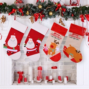 Set of four Christmas stockings with Santa and Reindeer designs hanging by a fireplace