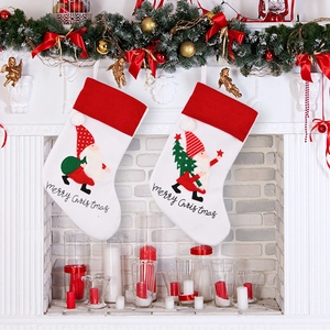 Two Christmas stockings with cartoon gnomes hanging on a festive decorated fireplace