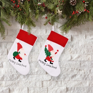 Set of red and white knitted Christmas stockings with gnome embroidery and pine tree decor