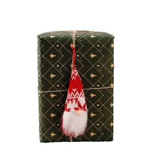 Charming red knitted Christmas gnome hanging ornament with white beard on a gift box