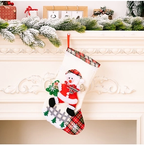 Detailed view of burlap Christmas stocking with snowman decor hanging on a cozy fireplace
