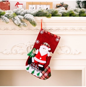 Hanging red burlap Christmas stocking with Santa Claus applique on a fireplace mantel