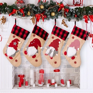 Set of four burlap Christmas stockings with gnome appliques on a festive fireplace mantel