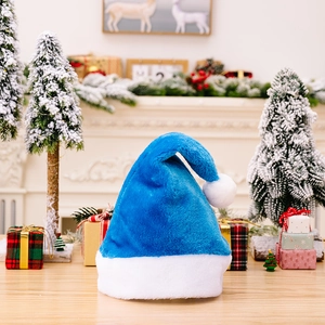 Premium royal blue plush Christmas hat with white pom-pom and fluffy brim in cozy setting