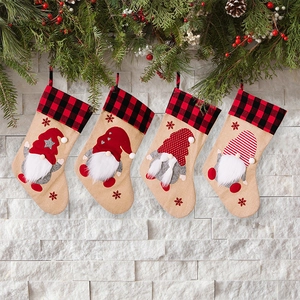 Set of 4 Christmas gnomes stockings with red and black buffalo plaid on white stone wall