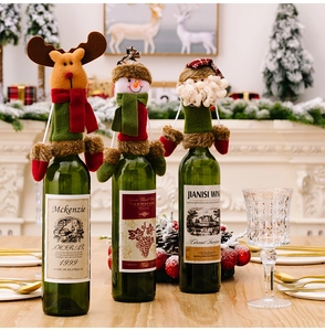 Detailed view of plush reindeer, snowman, and Santa wine bottle covers for Christmas decor