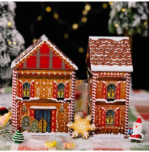 Macro view of gingerbread house shaped Christmas tin boxes with festive prints