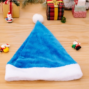 Plush blue and white Christmas hat on a wooden table with festive holiday decorations