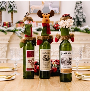 Three festive Christmas wine bottle covers featuring snowman, reindeer and Santa motifs