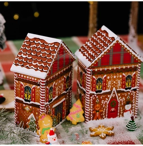 Detail of gingerbread house tin boxes with festive patterns and red plaid accents