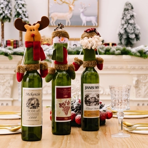 Three Christmas wine bottle covers featuring Santa Claus, reindeer, and snowman designs