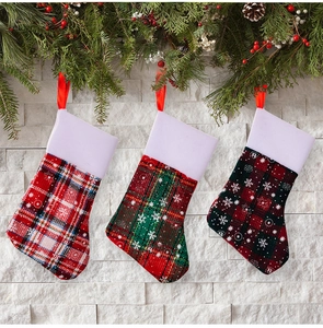 Plaid Christmas stocking cutlery holders with snowflake patterns on stone background