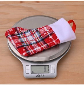 Close-up of lightweight 8.1g Christmas stocking cutlery holder with red plaid and snowflake