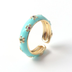 Détail de la bague en émail bleu clair avec fleurs dorées et zircons colorés