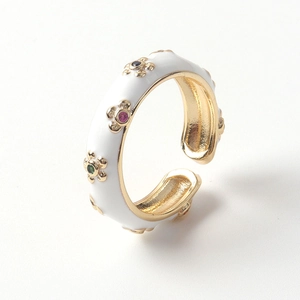 Détail de bague réglable dorée avec fleurs en émail blanc et zircons multicolores