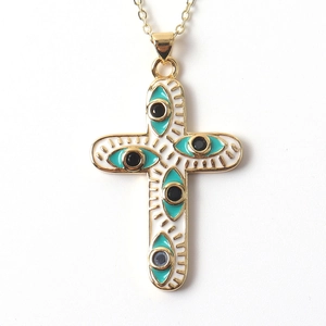 Close-up of gold cross pendant with white enamel and turquoise evil eye details