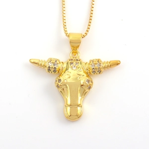 Macro view of gold bull head pendant featuring polished finish and sparkling crystal accents
