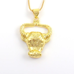 Detailed view of golden bull head pendant with intricate geometric relief patterns