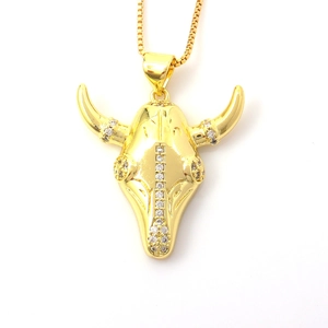 Detailed view of a gold bull head pendant necklace with sparkling white rhinestones