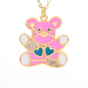 Macro shot of gold pendant necklace featuring pink enamel bear with heart-shaped cubic zirconia