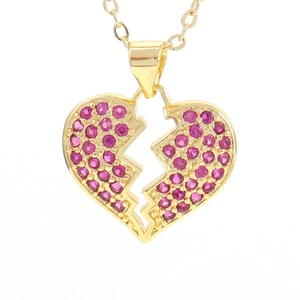 Macro shot of gold broken heart pendant with micro-pave pink cubic zirconia gems