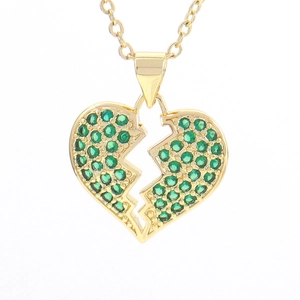 Macro shot of broken heart pendant necklace with green pave-set cubic zirconia