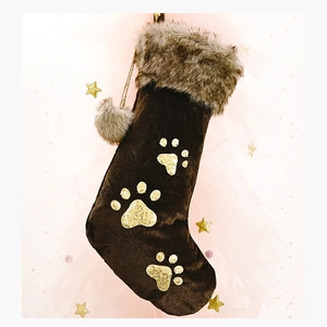 Détail de chaussette de Noël en velours marron avec pattes pailletées dorées et fausse fourrure