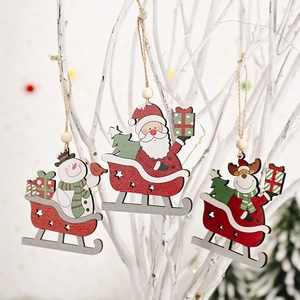 Detailed view of three festive wooden Christmas sled ornaments hanging on a white branch