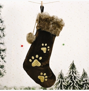 Détail d'une chaussette de Noël en velours marron avec pattes pailletées et bordure en fourrure