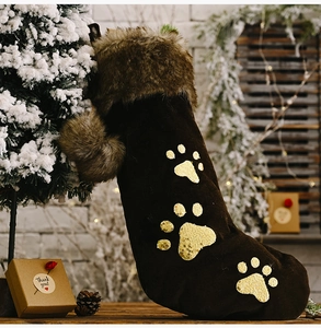 Détail d'une chaussette de Noël en velours marron avec fourrure et pattes de chien dorées