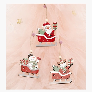 Close-up of wooden Christmas sled pendants with Santa and Snowman in a festive setting