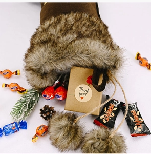 Gros plan d'une chaussette de Noël en suédine marron remplie de cadeaux et bonbons