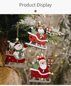 Close-up of wooden Santa, snowman and reindeer sleigh ornaments hanging on a Christmas tree