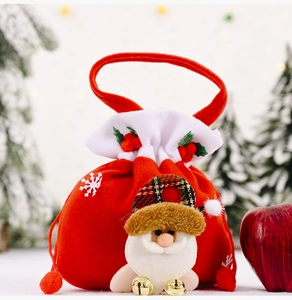 Detailed view of red velvet Christmas gift bag with Santa Claus 3D decor and gold bells