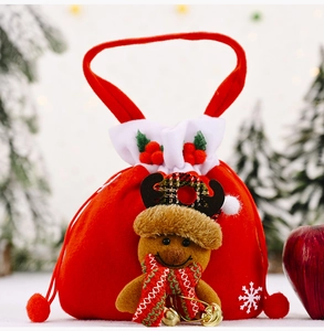 Close-up of red velvet Christmas gift bag with 3D reindeer doll and golden bells