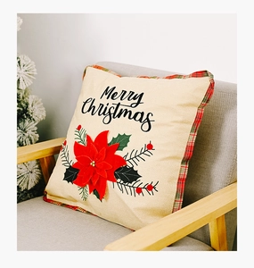 Detail of Christmas pillow cover with red poinsettia floral and Merry Christmas text