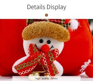 Close-up of velvet Christmas gift bag featuring a snowman doll with golden bells detail