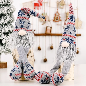 Detail of knitted grey Christmas gnomes with snowflake patterns on a birch log