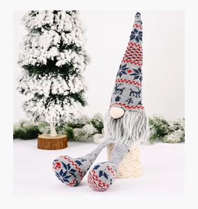 Detail of Christmas gnome with grey knit hat and snowflake pattern on birch wood
