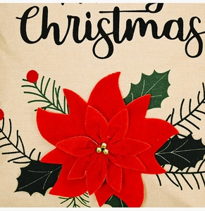 Detail of red poinsettia flower on Christmas pillowcase with festive embroidery