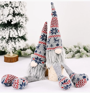 Close-up of Nordic knitted Christmas gnomes with grey beards and snowflake patterns in snow