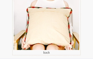 Detail of red and green plaid border and beige linen fabric on cushion cover back