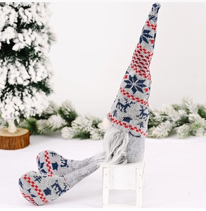 Detail of Christmas knitted gnome doll with grey long beard and festive reindeer patterns