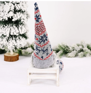 Detail of Christmas gnome plush doll featuring knitted snowflake and reindeer patterns