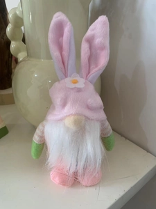 Close-up of Easter rabbit gnome with pink ears, white beard and floral hat detail