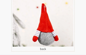 Rear view detail of a plush Christmas gnome ornament with red hat and striped arms