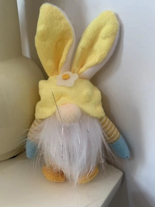 Detail of Easter gnome plush with yellow bunny ears and striped blue sleeves ornament