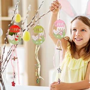 Close-up of Easter wooden egg pendants with hollow chicken motifs and rustic ribbons