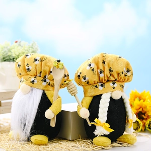 Detailed close-up of handmade bumblebee gnome plush with yellow patterns and wooden spoon