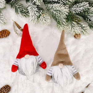 Christmas striped gnome ornaments with long beards and pointed hats on snowy background